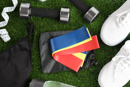 Flat lay composition with fitness elastic bands on green grassの写真素材