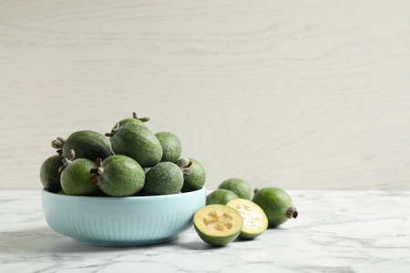 Fresh green feijoa fruits on white marble table, space for textの写真素材