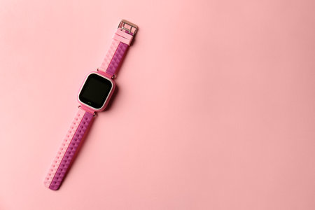 Trendy kid smart watch on pink background, top view. Space for textの写真素材