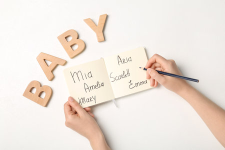 Woman choosing baby name at white table, top viewの写真素材