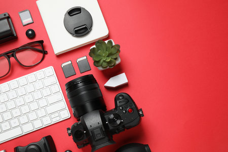 Flat lay composition with camera and video production equipment on red background. Space for textの写真素材