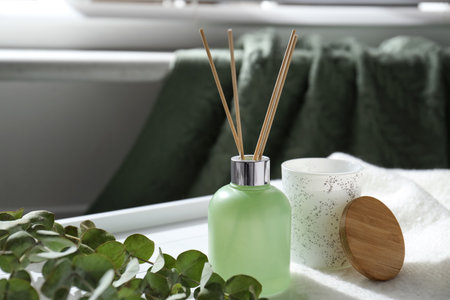 Reed air freshener and eucalyptus branches on tray indoors