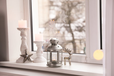 Decorative Christmas lantern and candles on windowsillの写真素材