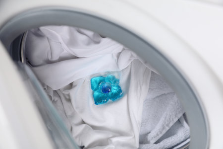 Laundry detergent capsule in washing machine drum, closeup viewの写真素材