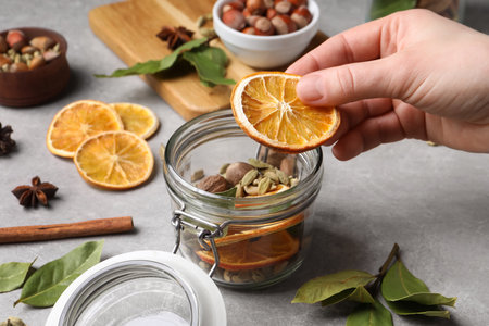 Woman making aromatic potpourri at gray table, closeupの写真素材