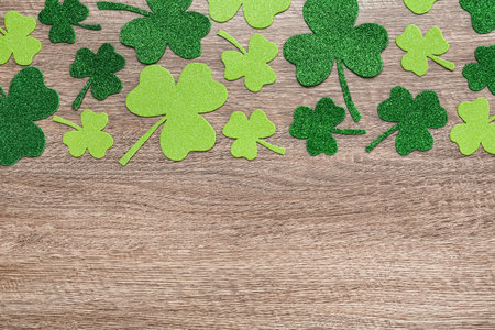 Decorative clover leaves on gray wooden table, flat lay with space for text. Saint Patrick's Day celebrationの写真素材