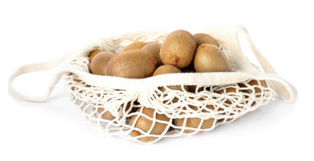 Whole fresh kiwis in net bag isolated on whiteの写真素材