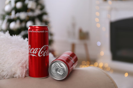 MYKOLAIV, UKRAINE - JANUARY 13, 2021: Cans of Cola-Cola in room with Christmas tree, space for textのeditorial素材