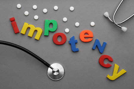 Flat lay composition with word IMPOTENCY on gray backgroundの写真素材