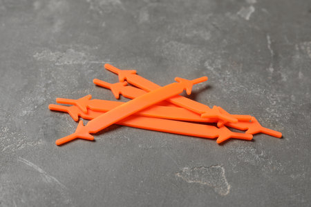 Orange silicone shoelaces on gray stone background