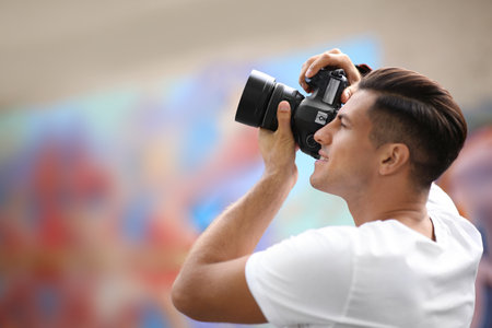Photographer taking picture with professional camera outdoorsの写真素材