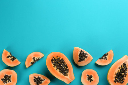 Fresh ripe papaya fruits on blue background, flat lay. Space for textの写真素材
