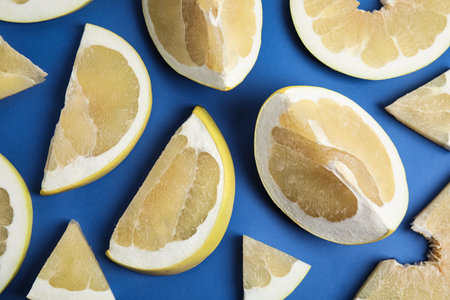 Slices of delicious ripe pomelo on blue background, flat layの写真素材