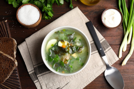 Delicious sorrel soup served on brown wooden table, flat layの写真素材