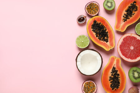 Fresh ripe papaya and other fruits on pink background, flat lay. Space for textの写真素材