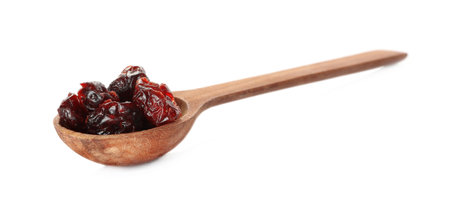 Dried cranberries in wooden spoon isolated on whiteの写真素材
