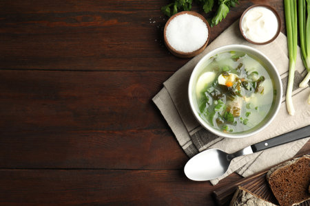 Delicious sorrel soup served on brown wooden table, flat lay. Space for textの写真素材
