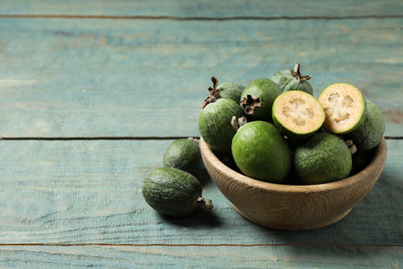 Fresh green feijoa fruits on blue wooden table, space for textの写真素材