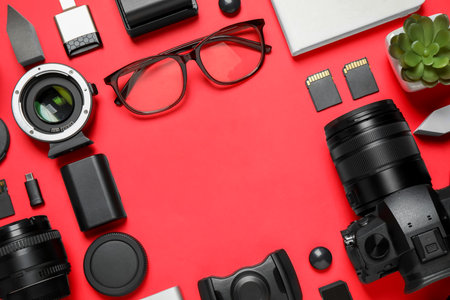 Flat lay composition with camera and video production equipment on red background. Space for textの写真素材