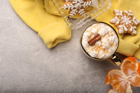 Flat lay composition with delicious marshmallow drink and yellow sweater on light gray table. Space for textの写真素材