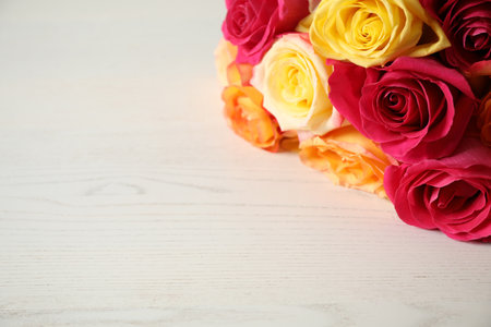 Luxury bouquet of fresh roses on white wooden table, closeup. Space for textの写真素材