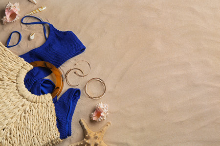 Different beach accessories on sand, flat lay. Space for textの写真素材
