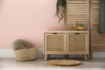 Wooden commode near pink wall in room. interior designの写真素材