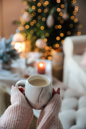 Woman with cup of cocoa in room decorated for Christmas, closeupの写真素材