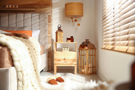 Cozy bedroom interior with vintage lanterns and knitted blanketの写真素材