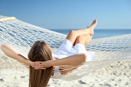 Young woman relaxing in hammock on the beachの写真素材