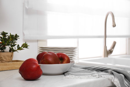 Bowl with ripe apples on the counter in the kitchenの写真素材