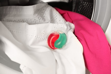 Laundry detergent capsule and clothes in washing machineの写真素材