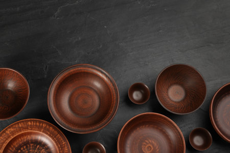 Set of clay dishes on black table, flat lay. Space for textの写真素材