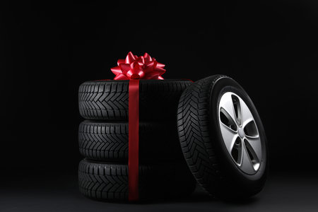 Gift set of wheels with winter tires on black backgroundの写真素材