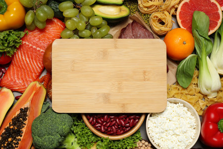 Wooden board among different products, top view with space for text. Healthy food and balanced dietの写真素材