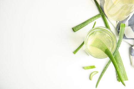 Fresh aloe drink and leaves on white table, flat lay. Space for textの写真素材