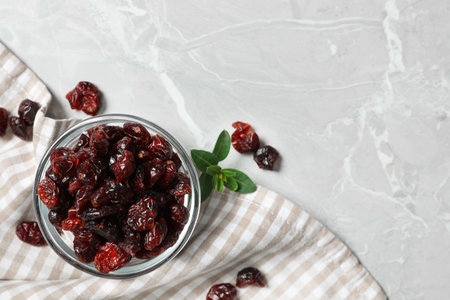 Bowl of dried cranberries on light gray marble table, flat lay. Space for textの写真素材