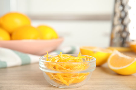 Grated lemon zest and fresh fruits on wooden tableの写真素材