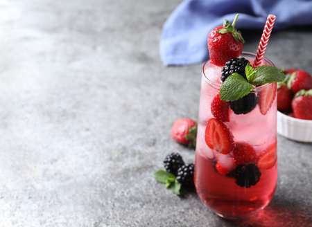 Delicious strawberry lemonade with soda water, mint and blackberries on gray table, space for text. fresh summer cocktailの写真素材