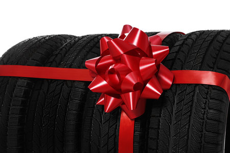 Winter tires with red ribbon on white background, closeupの写真素材