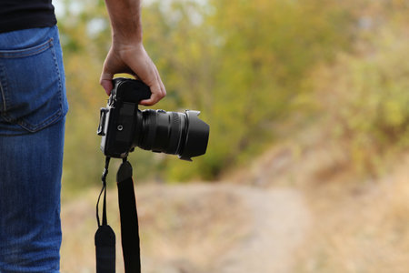 Photographer with professional camera in countryside closeupの写真素材