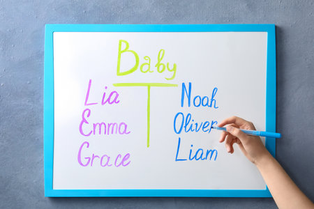 Woman writing list of baby names on white board, closeupの写真素材
