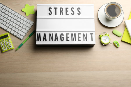 Flat lay composition of lightbox with phrase Stress Management on wooden table. Space for textの写真素材