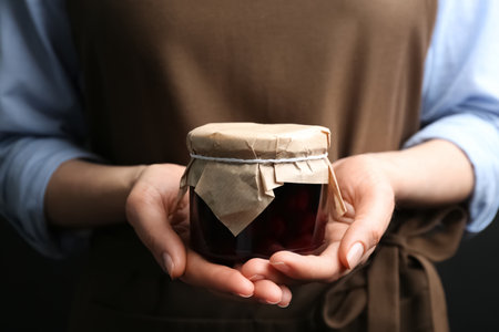 Woman holding glass jar of pickled cherries, closeupの写真素材