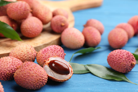 Fresh ripe lychee fruits on blue wooden tableの写真素材