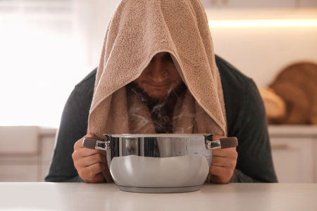 Man taking treatments at table indoors. Steam inhalationの写真素材
