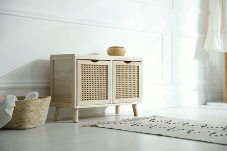 Wooden commode near white wall in room. interior design