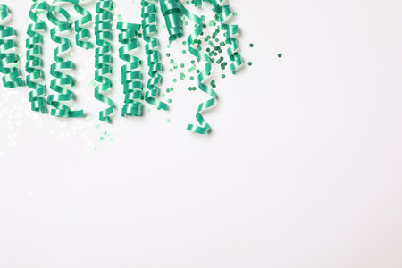 Turquoise serpentine streamers and confetti on white background, top viewの写真素材