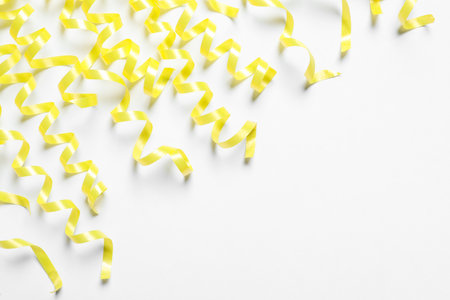 Many yellow serpentine streamers on white backgroundの写真素材