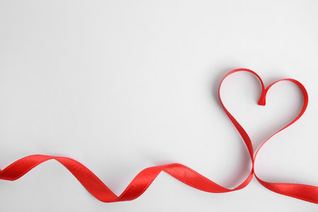 Heart made of red ribbon on white background, top view. Valentine's day celebrationの写真素材